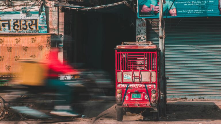 Motion blur of a scooter speeding past a vibrant street scene in Patna, India.